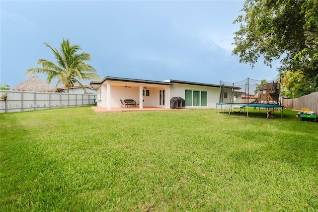 9471 SW 10th St, Miami, FL 33174 - back of property featuring a trampoline, a ceiling fan, stucco siding, a fenced backyard, and a patio area