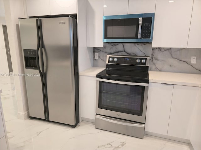 7771 NW 46th St, Lauderhill, FL 33351 - kitchen featuring appliances with stainless steel finishes, light marble finish flooring, white cabinets, and light countertops