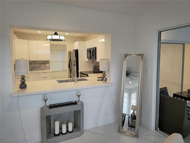 7771 NW 46th St, Lauderhill, FL 33351 - kitchen with stainless steel appliances, light marble finish floors, modern cabinets, white cabinetry, and light countertops