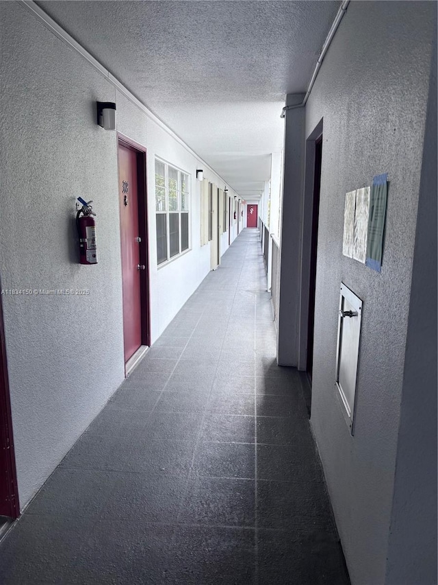 1301 SW 134th Way Unit 307B, Pembroke Pines, FL 33027 - corridor featuring a textured wall and a textured ceiling