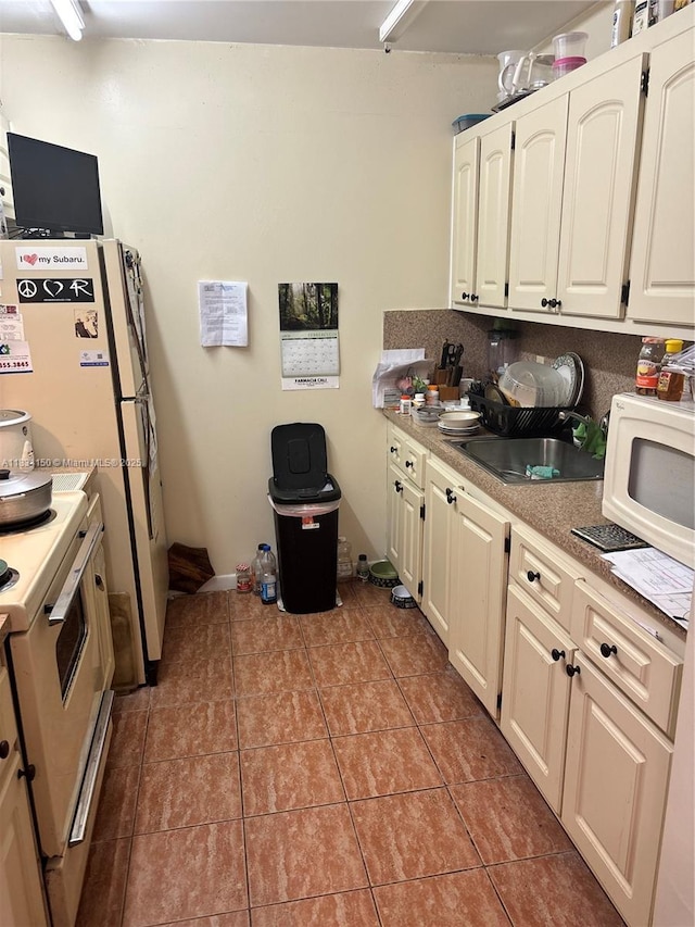 1301 SW 134th Way Unit 307B, Pembroke Pines, FL 33027 - kitchen with white appliances, light tile patterned flooring, light countertops, and white cabinetry