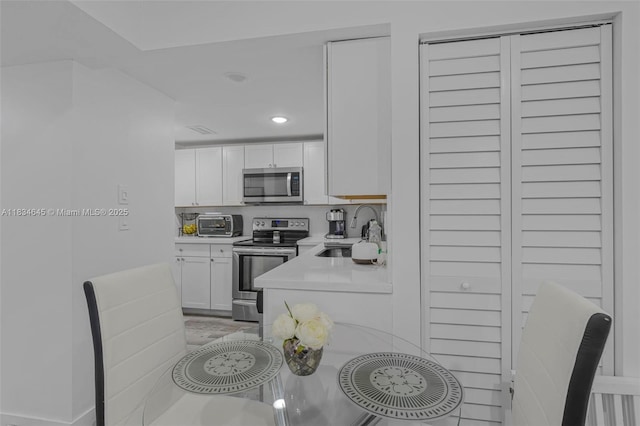 11955 SW 18th Ter Unit 9, Miami, FL 33175 - kitchen with appliances with stainless steel finishes, light countertops, white cabinets, and recessed lighting