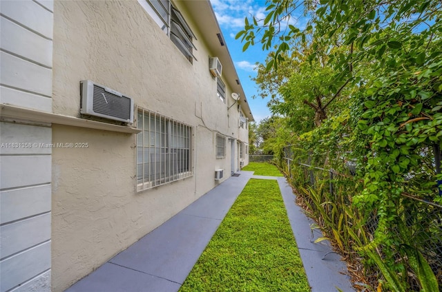 842 NW 1st Ave, Fort Lauderdale, FL 33311 - view of property exterior with a wall unit AC, stucco siding, and a wall mounted air conditioner