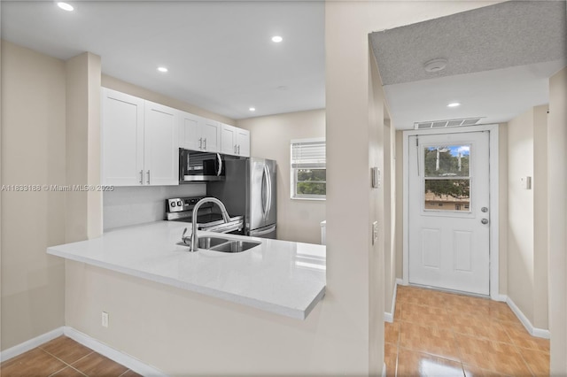 3405 NW 48th Ave Unit 610, Lauderdale Lakes, FL 33319 - kitchen featuring stainless steel appliances, light countertops, healthy amount of natural light, white cabinetry, and recessed lighting