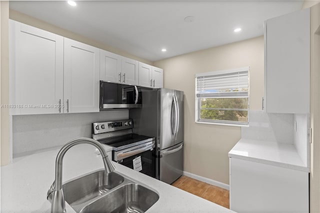 3405 NW 48th Ave Unit 610, Lauderdale Lakes, FL 33319 - kitchen featuring appliances with stainless steel finishes, light countertops, light wood-type flooring, white cabinets, and recessed lighting