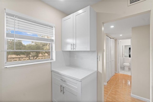 3405 NW 48th Ave Unit 610, Lauderdale Lakes, FL 33319 - kitchen with light countertops, recessed lighting, white cabinets, light tile patterned floors, and backsplash