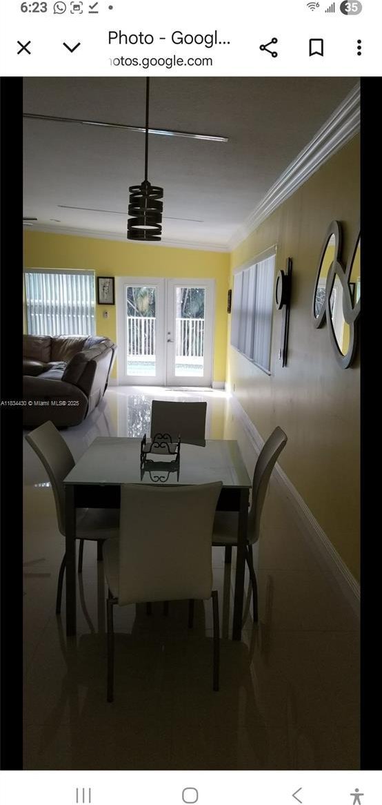 dining room featuring crown molding and tile patterned flooring