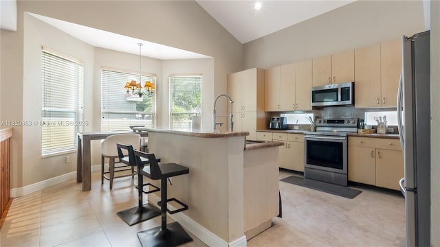 1891 SW 156th Ave, Miramar, FL 33027 - kitchen featuring appliances with stainless steel finishes, vaulted ceiling, a chandelier, an island with sink, and pendant lighting