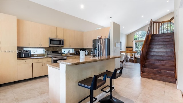 1891 SW 156th Ave, Miramar, FL 33027 - kitchen with stainless steel appliances, a breakfast bar area, high vaulted ceiling, decorative backsplash, and an island with sink