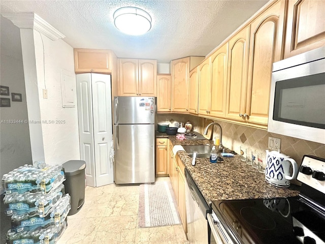 2841 NE 33rd Ct Unit 104, Fort Lauderdale, FL 33306 - kitchen with stainless steel appliances, light brown cabinetry, tasteful backsplash, and a textured ceiling