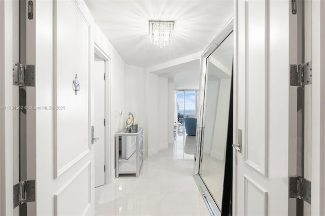 848 Brickell Key Dr Unit 2705, Miami, FL 33131 - corridor with a chandelier and light tile patterned floors