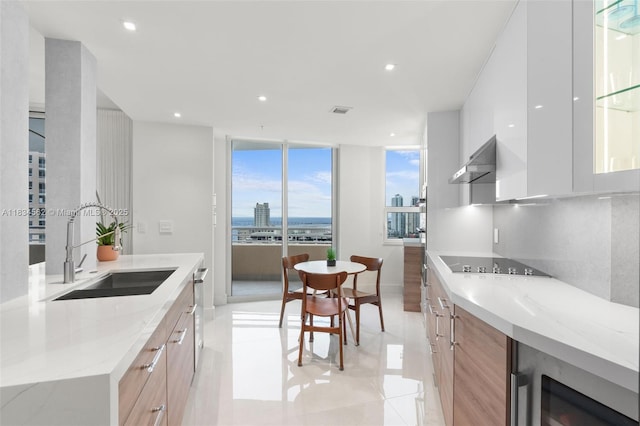 848 Brickell Key Dr Unit 2705, Miami, FL 33131 - kitchen featuring modern cabinets, black electric stovetop, ventilation hood, beverage cooler, and floor to ceiling windows