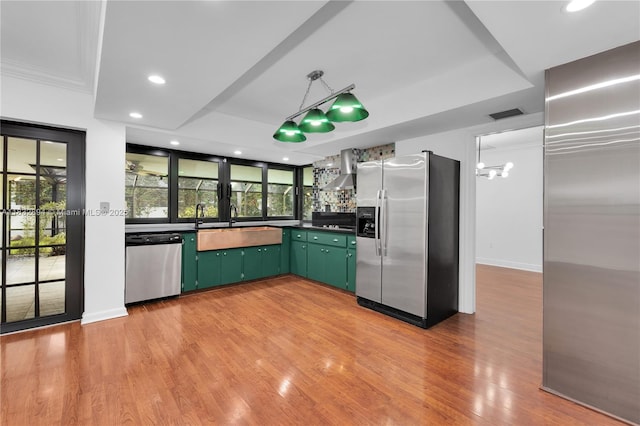 7804 SW 178th Ter, Palmetto Bay, FL 33157 - kitchen with stainless steel appliances, green cabinetry, wall chimney range hood, light wood finished floors, and recessed lighting