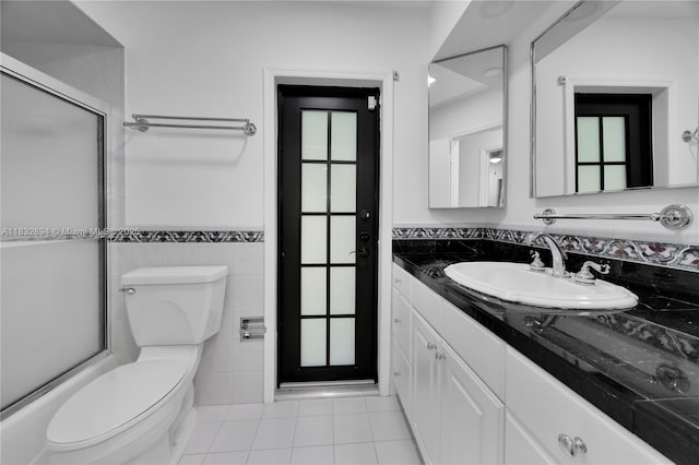 7804 SW 178th Ter, Palmetto Bay, FL 33157 - full bathroom featuring vanity, tile patterned flooring, tile walls, shower / bath combination with glass door, and a wainscoted wall