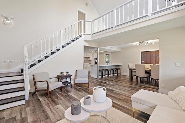 7264 159th Ct N, Palm Beach Gardens, FL 33418 - living room with stairway, a towering ceiling, wood finished floors, and a chandelier