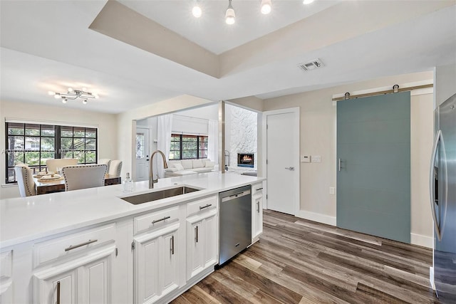 7264 159th Ct N, Palm Beach Gardens, FL 33418 - kitchen featuring appliances with stainless steel finishes, light countertops, dark wood-style flooring, white cabinetry, and a barn door