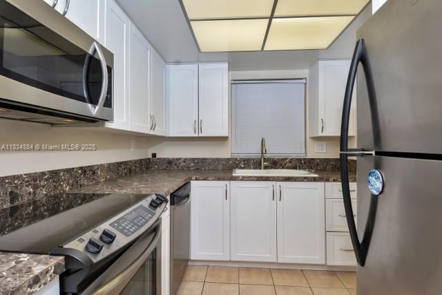 2101 NE 68th St Unit 103, Fort Lauderdale, FL 33308 - kitchen with stainless steel appliances, light tile patterned flooring, and white cabinetry