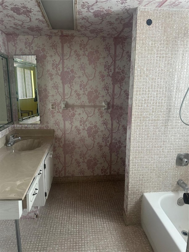 5945 Del Lago Cir Unit 201, Sunrise, FL 33313 - full bathroom featuring vanity, tile patterned flooring, wallpapered walls, and washtub / shower combination