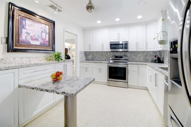 12000 NW 20th St, Pembroke Pines, FL 33026 - kitchen featuring appliances with stainless steel finishes, backsplash, light stone countertops, white cabinets, and recessed lighting
