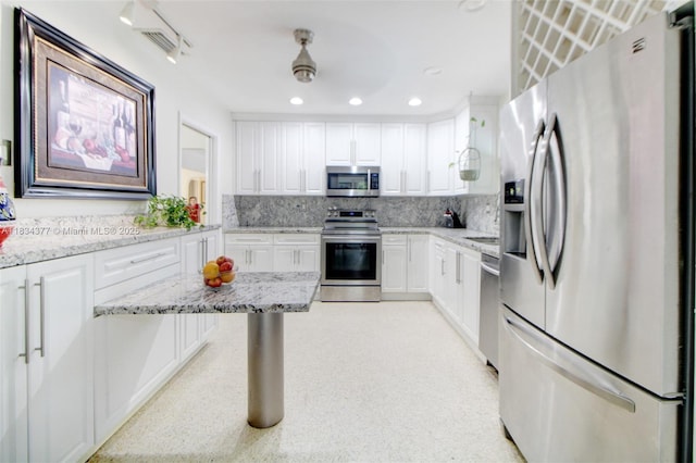 12000 NW 20th St, Pembroke Pines, FL 33026 - kitchen featuring stainless steel appliances, white cabinets, light stone counters, decorative backsplash, and recessed lighting