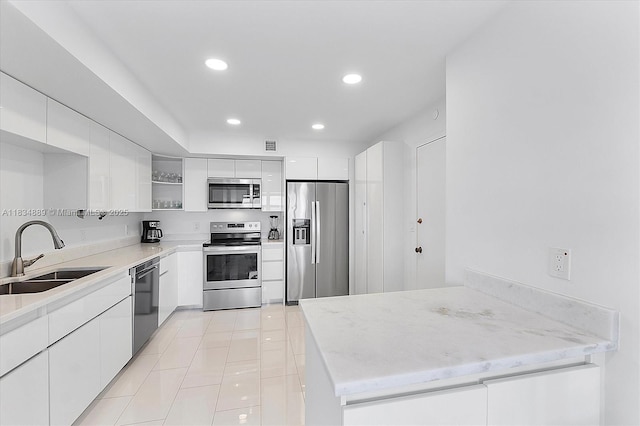 3400 Galt Ocean Dr Unit 702S, Fort Lauderdale, FL 33308 - kitchen featuring stainless steel appliances, open shelves, white cabinetry, light tile patterned floors, and a peninsula