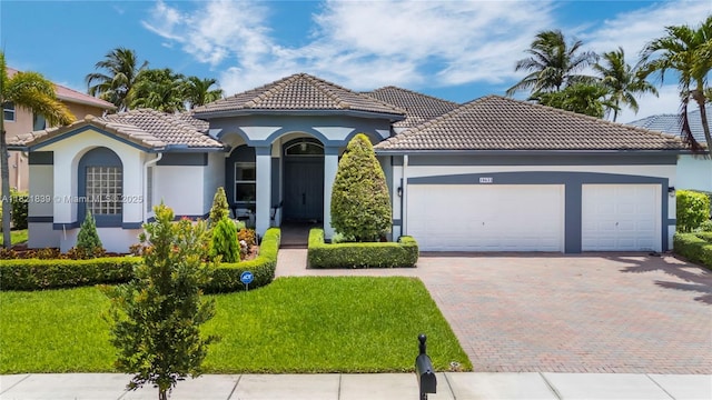 18633 SW 24th St, Miramar, FL 33029 - mediterranean / spanish-style house featuring decorative driveway, a garage, stucco siding, a tile roof, and a front lawn