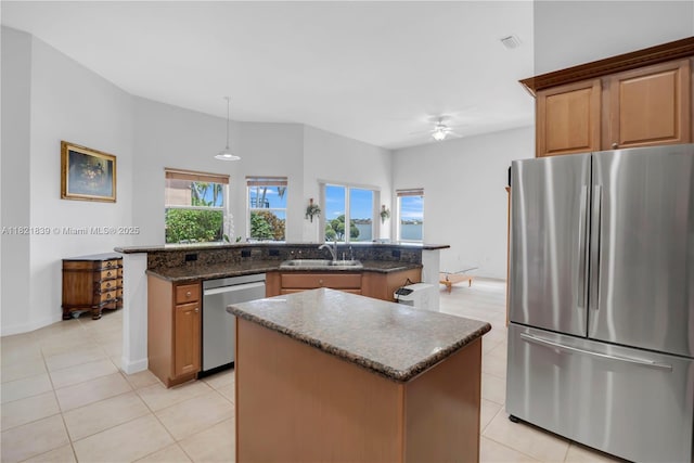 18633 SW 24th St, Miramar, FL 33029 - kitchen with stainless steel appliances, a center island, light tile patterned floors, a ceiling fan, and dark stone countertops