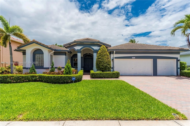 18633 SW 24th St, Miramar, FL 33029 - mediterranean / spanish-style home with stucco siding, decorative driveway, a front yard, an attached garage, and a tiled roof