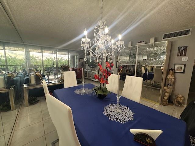 3910 Inverrary Blvd Unit 603-B, Lauderhill, FL 33319 - dining space with a textured ceiling, tile patterned floors, a chandelier, and a wall of windows