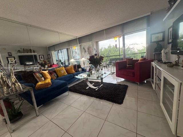 3910 Inverrary Blvd Unit 603-B, Lauderhill, FL 33319 - living room featuring a textured ceiling and light tile patterned flooring