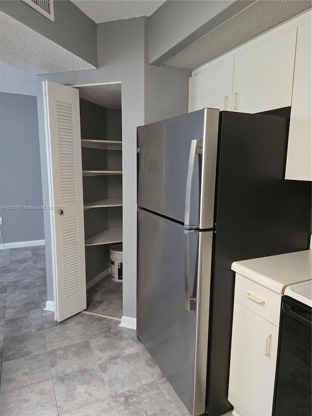 800 SW 142nd Ave Unit N111, Pembroke Pines, FL 33027 - kitchen featuring light countertops, freestanding refrigerator, white cabinets, and a textured ceiling