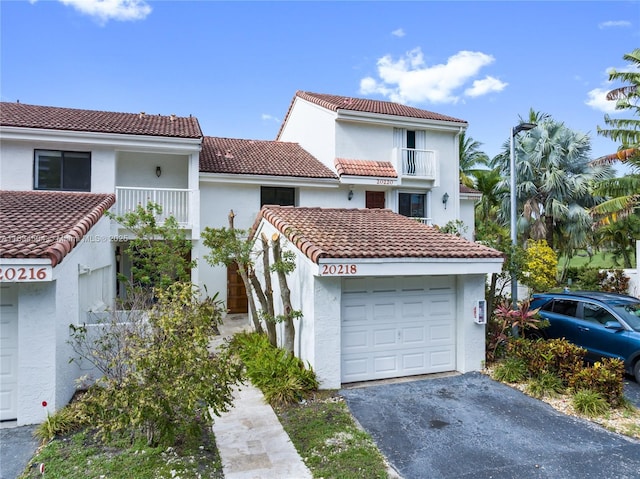 20218 NE 34th Ct Unit 52, Aventura, FL 33180 - mediterranean / spanish-style house featuring a balcony, driveway, stucco siding, and a tile roof