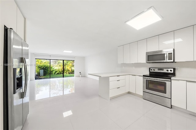 20218 NE 34th Ct Unit 52, Aventura, FL 33180 - kitchen featuring appliances with stainless steel finishes, modern cabinets, white cabinets, light countertops, and a peninsula