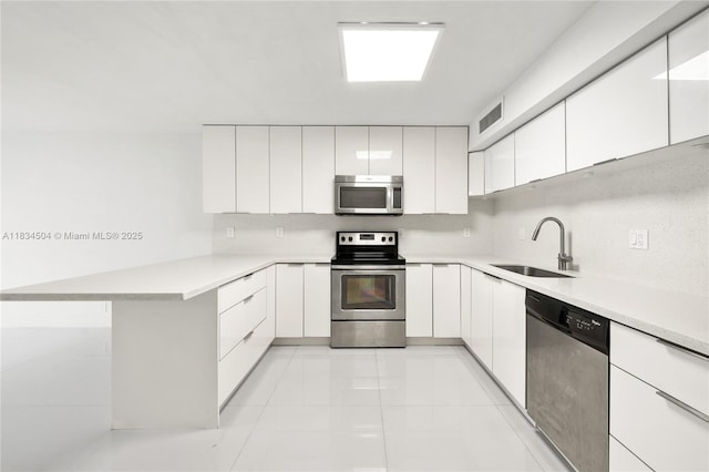 20218 NE 34th Ct Unit 52, Aventura, FL 33180 - kitchen featuring appliances with stainless steel finishes, a peninsula, white cabinetry, and light countertops
