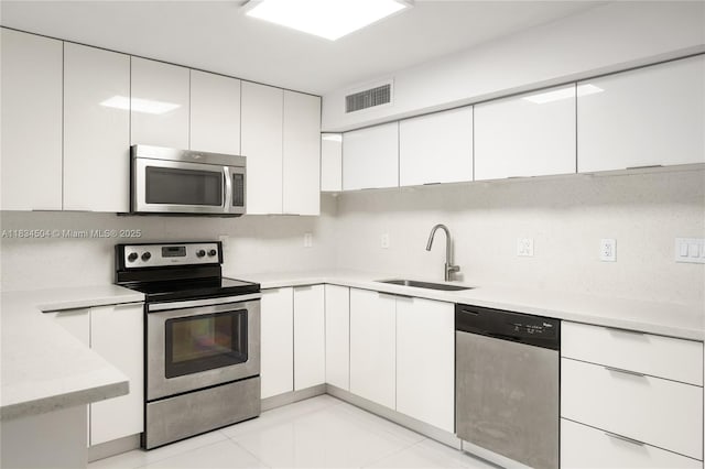 20218 NE 34th Ct Unit 52, Aventura, FL 33180 - kitchen with appliances with stainless steel finishes, white cabinetry, light countertops, and modern cabinets