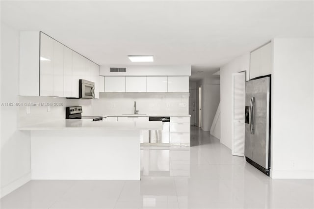 20218 NE 34th Ct Unit 52, Aventura, FL 33180 - kitchen featuring appliances with stainless steel finishes, modern cabinets, light countertops, a peninsula, and white cabinetry