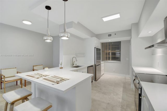 3205 NE 184th St Unit 9106, Aventura, FL 33160 - kitchen with appliances with stainless steel finishes, a breakfast bar area, wall chimney range hood, white cabinets, and light countertops