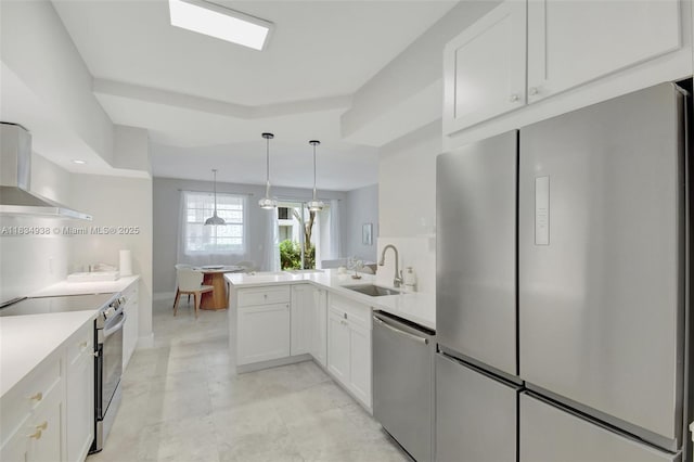 3205 NE 184th St Unit 9106, Aventura, FL 33160 - kitchen with appliances with stainless steel finishes, wall chimney exhaust hood, a peninsula, white cabinetry, and light countertops