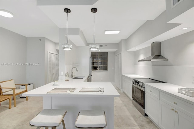 3205 NE 184th St Unit 9106, Aventura, FL 33160 - kitchen featuring stainless steel range with electric stovetop, wall chimney range hood, light countertops, and white cabinetry