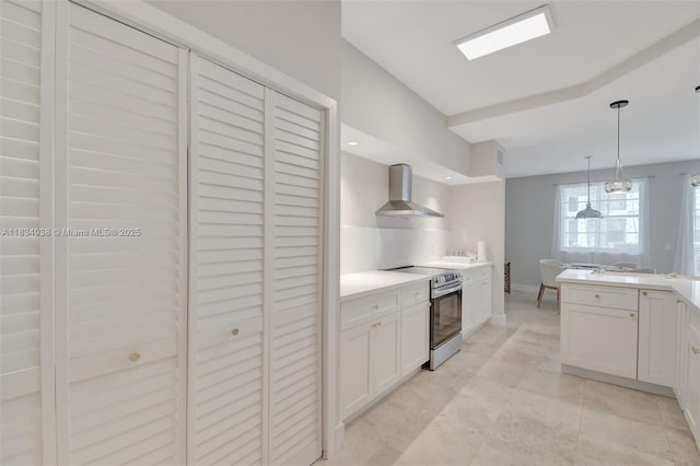 3205 NE 184th St Unit 9106, Aventura, FL 33160 - kitchen featuring wall chimney exhaust hood, stainless steel range with electric cooktop, white cabinets, and decorative light fixtures