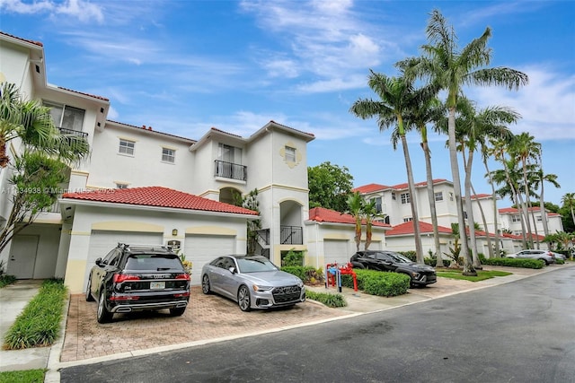3205 NE 184th St Unit 9106, Aventura, FL 33160 - view of front of property featuring stucco siding, an attached garage, a residential view, and decorative driveway