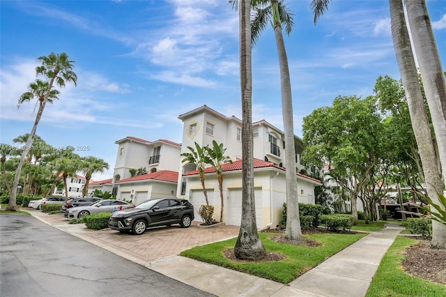 3205 NE 184th St Unit 9106, Aventura, FL 33160 - view of front of house with an attached garage, stucco siding, a tile roof, and decorative driveway