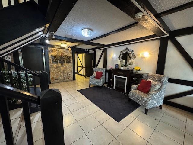 3690 Inverrary Dr Unit 1T, Lauderhill, FL 33319 - home theater room with tile patterned floors, a textured ceiling, and a fireplace