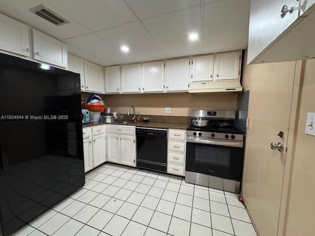 3690 Inverrary Dr Unit 1T, Lauderhill, FL 33319 - kitchen with black appliances, under cabinet range hood, dark countertops, light tile patterned flooring, and a drop ceiling
