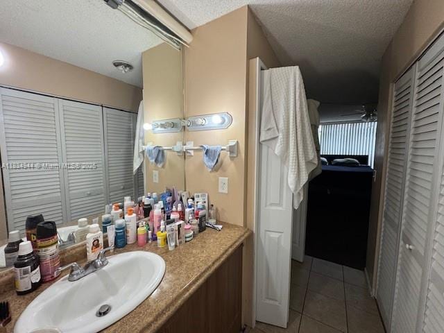 3690 Inverrary Dr Unit 1T, Lauderhill, FL 33319 - bathroom featuring a closet, vanity, tile patterned floors, and a textured ceiling