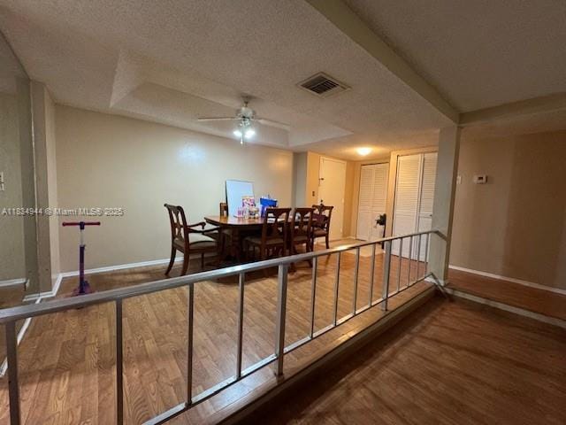 3690 Inverrary Dr Unit 1T, Lauderhill, FL 33319 - interior space with wood finished floors, a ceiling fan, a textured ceiling, and a raised ceiling