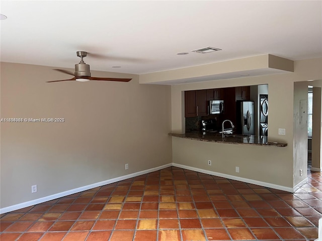 3016 NE 21st Ter Unit 3016, Fort Lauderdale, FL 33306 - kitchen with estacked washer and dryer, stainless steel appliances, ceiling fan, tasteful backsplash, and tile patterned flooring