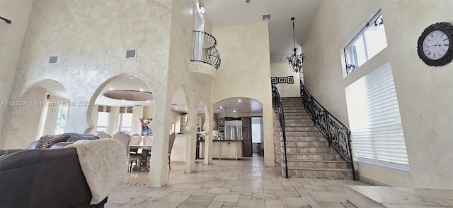 3460 SW 52nd St, Hollywood, FL 33312 - living area with a towering ceiling, stone tile floors, stairway, and arched walkways