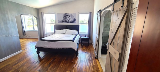 3460 SW 52nd St, Hollywood, FL 33312 - bedroom with a barn door, hardwood / wood-style floors, vaulted ceiling, and arched walkways