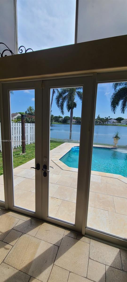 3460 SW 52nd St, Hollywood, FL 33312 - entryway featuring stone tile flooring, a water view, french doors, and healthy amount of natural light